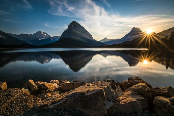 Coucher de soleil sur fond de montagnes et de lac