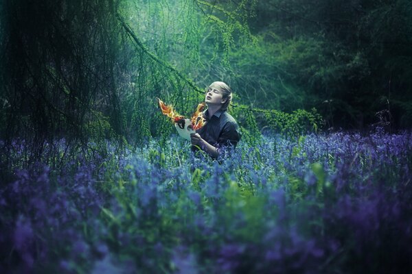 Guy avec le feu dans la forêt dans la clairière