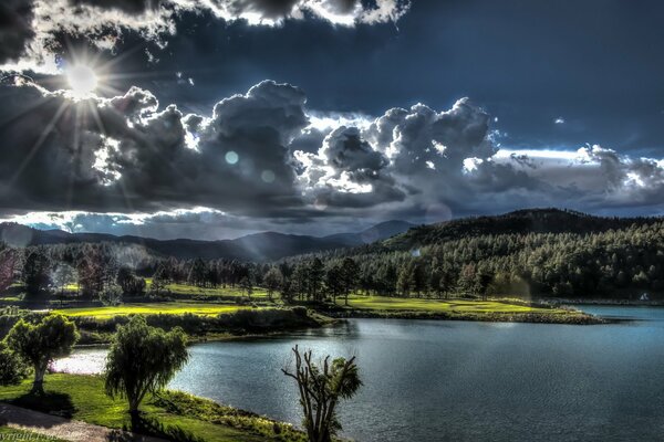 Schöne Wolken über dem See in der Nähe des Waldes