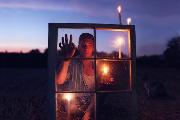 El chico con una vela Mira a través de la ventana