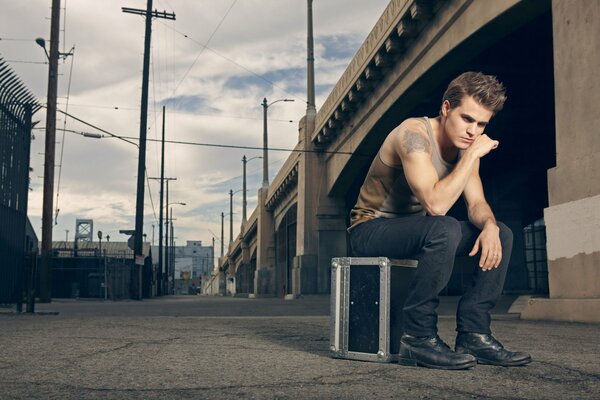 Paul Wesley sur une valise sous le pont