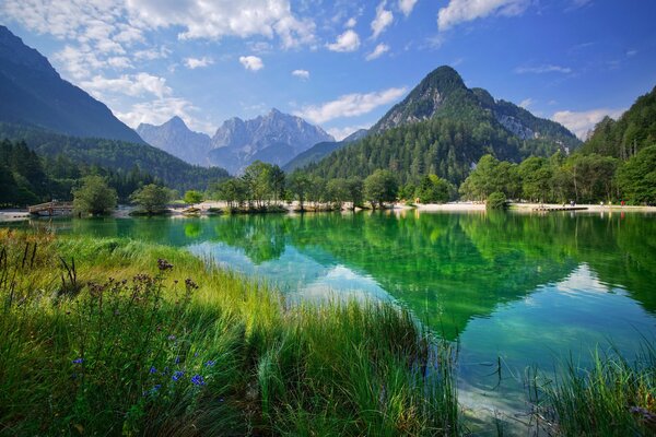 Montañas y nubes se reflejan en el lago