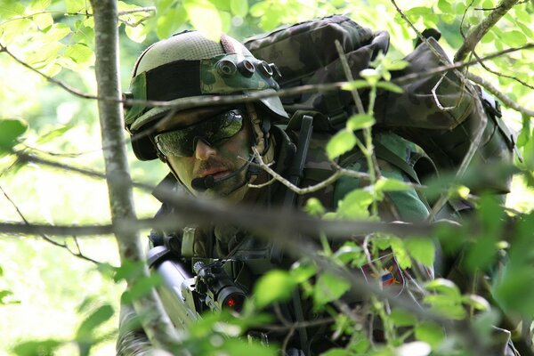 Soldat im Wald hinter Zweigen