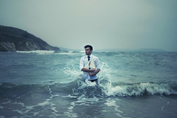 Homme debout dans la mer avec un navire