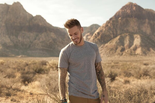 Chanteur français souriant sur fond de montagnes