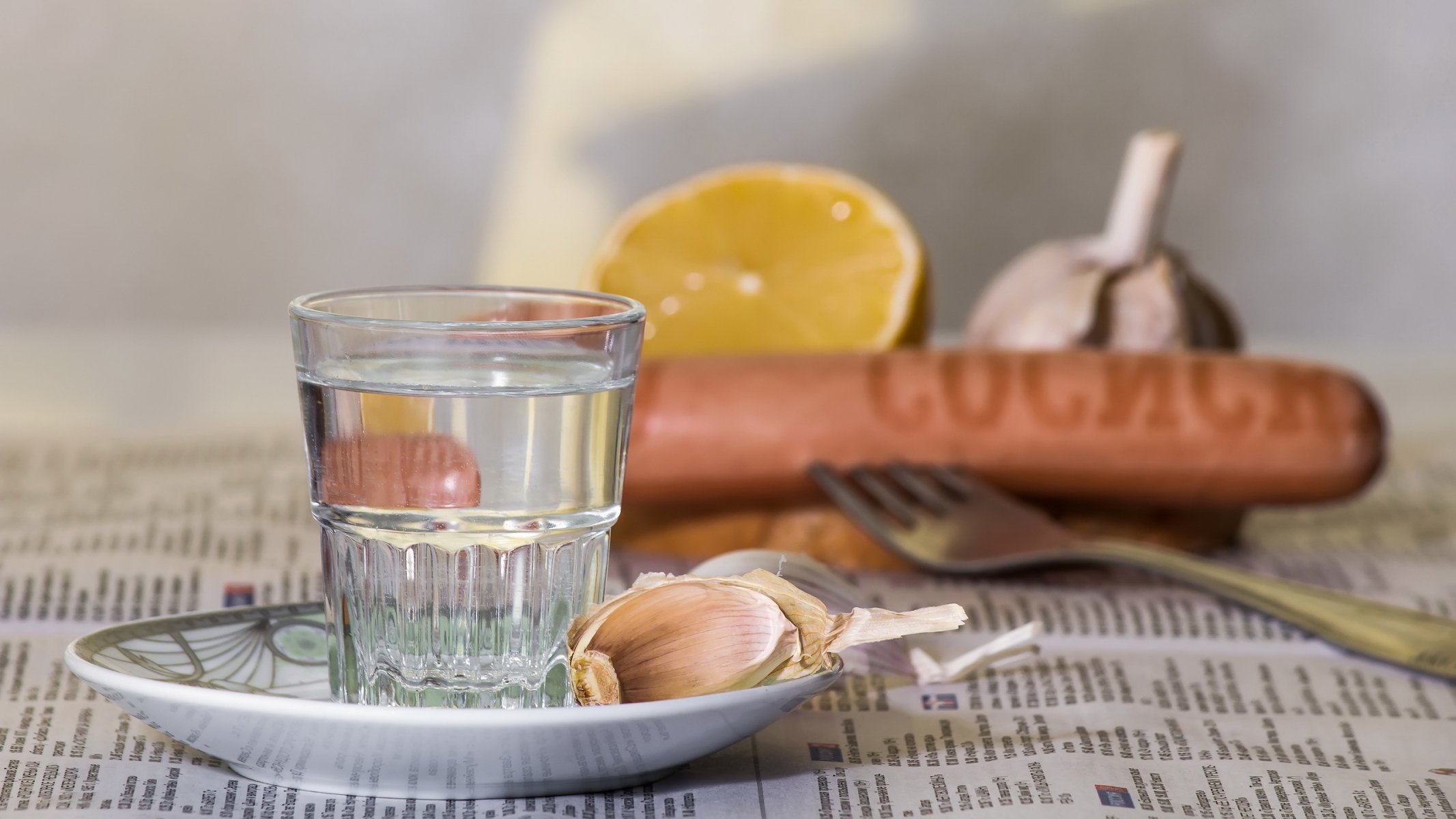 alcol vodka snack composizione limone natura morta stoviglie rifrazione prodotti bicchiere salsiccia aglio