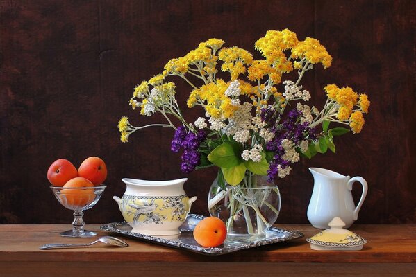 Apricots and flowers are on the table