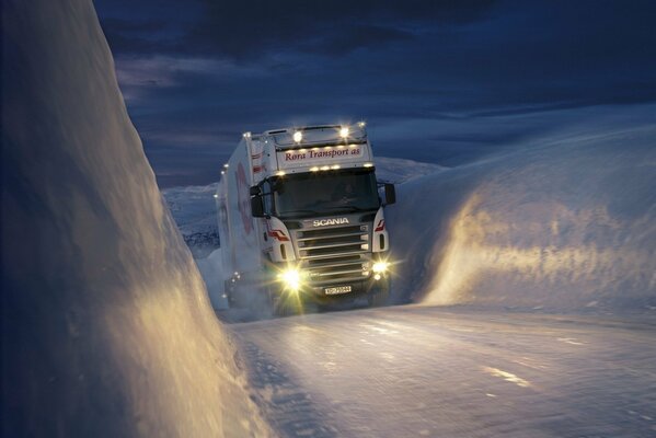 A white truck making its way through the ice against the background of the night sky