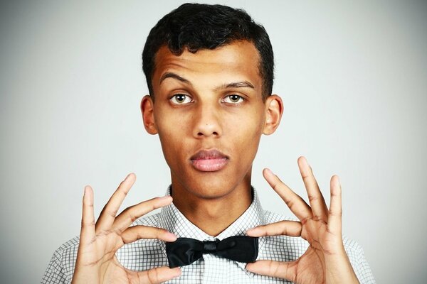 Stromae-Sänger hält einen Schmetterling