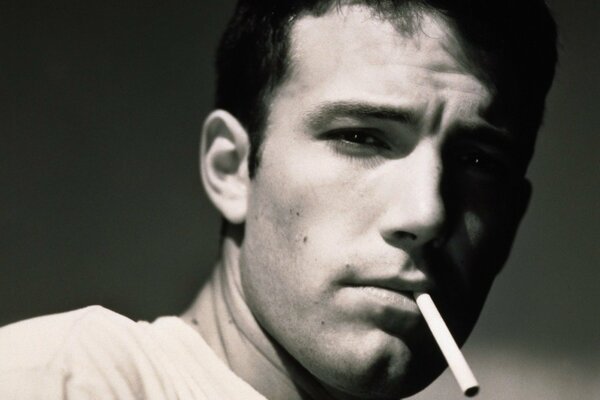 Ben Affleck con un cigarrillo en la boca mirando a la lente