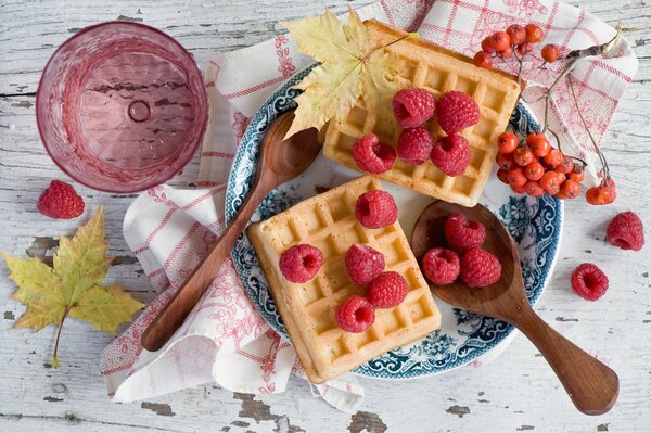 Waffles with raspberries on a blue plate