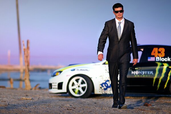 Homme en costume sur fond de voiture