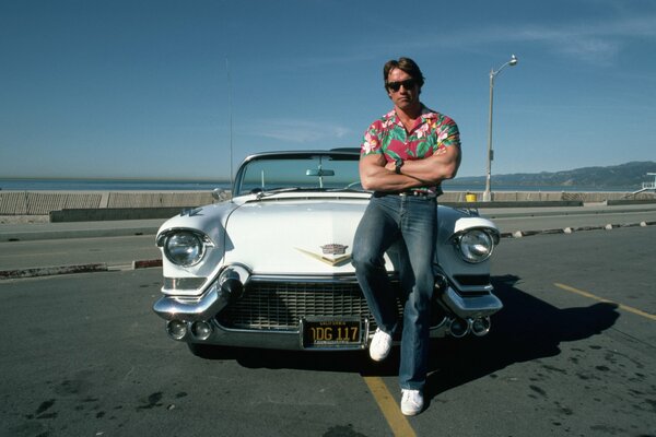 A young Terminator poses on a white Cadillac