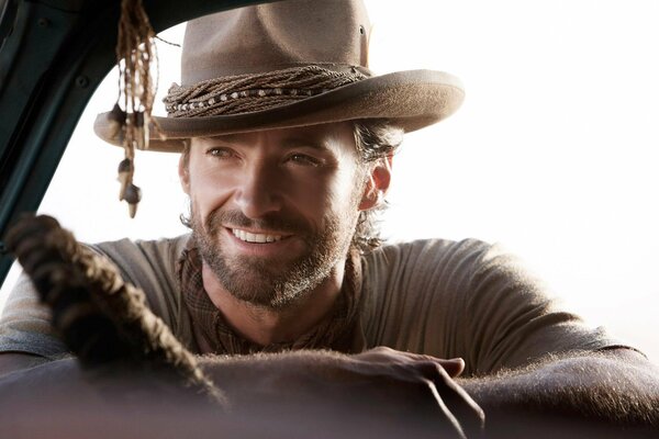 Hugh Jackman sourit avec charme dans un chapeau de cow-Boy