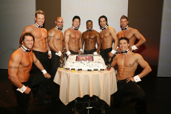 Strippers jocks with a naked torso give a cake