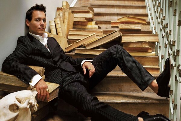 Johnny Depp on the stairs among the books