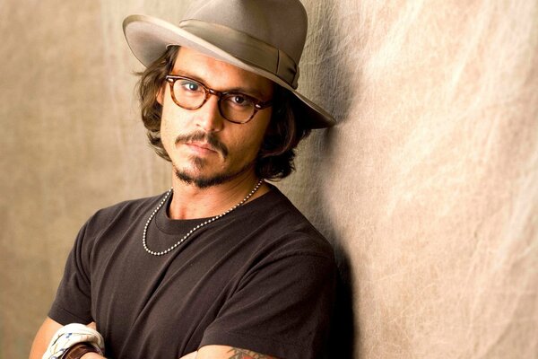 Johnny Depp con un sombrero contra la pared