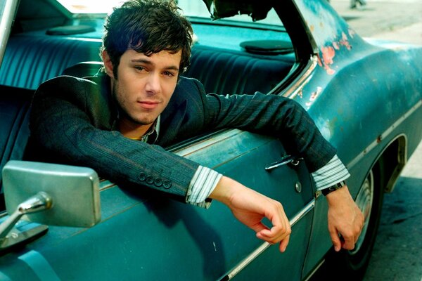 Adam Brody auf einem Retro-Auto