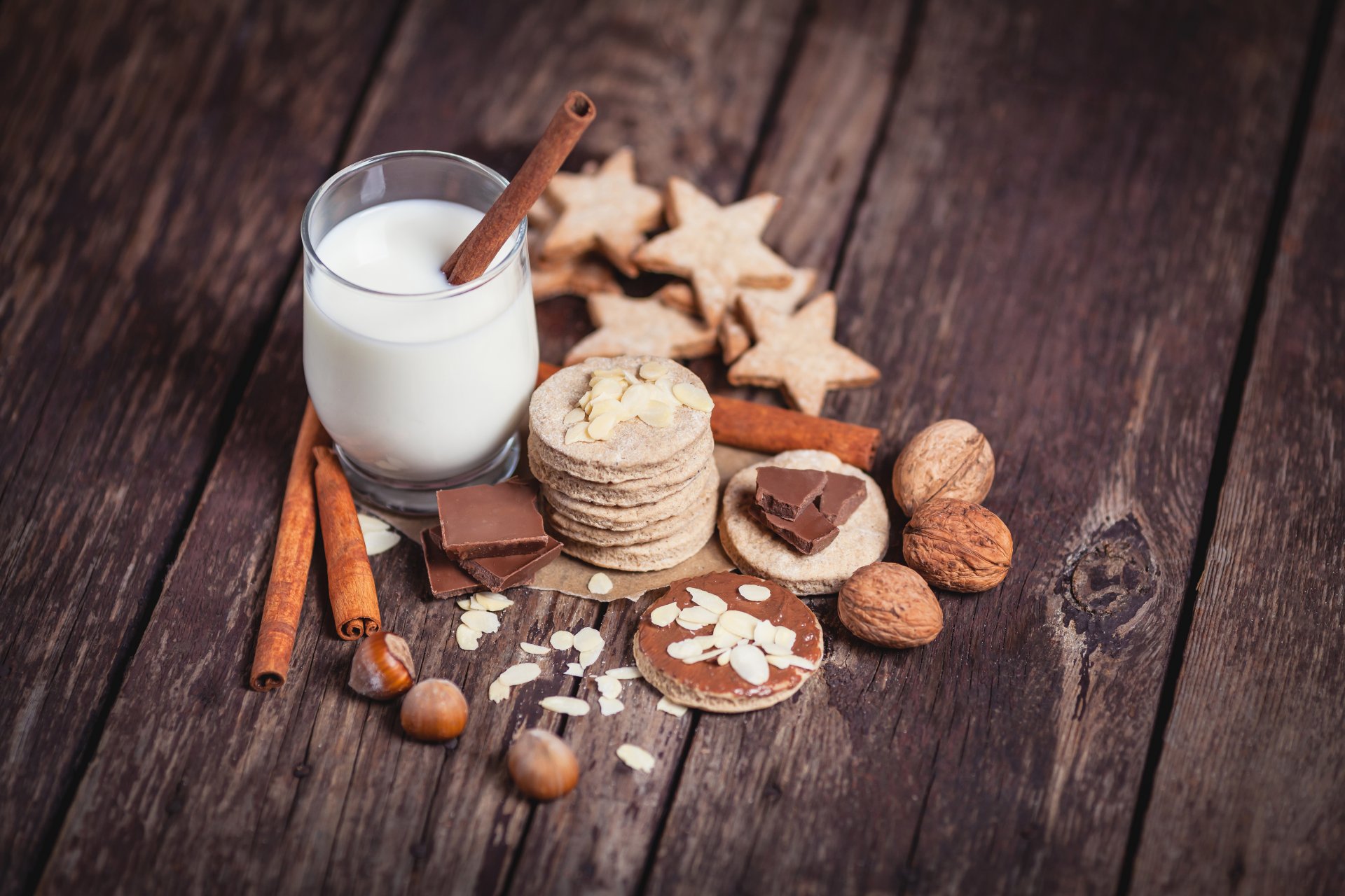 verre lait cannelle bâtonnets noix noisettes noix amandes biscuits chocolat planches