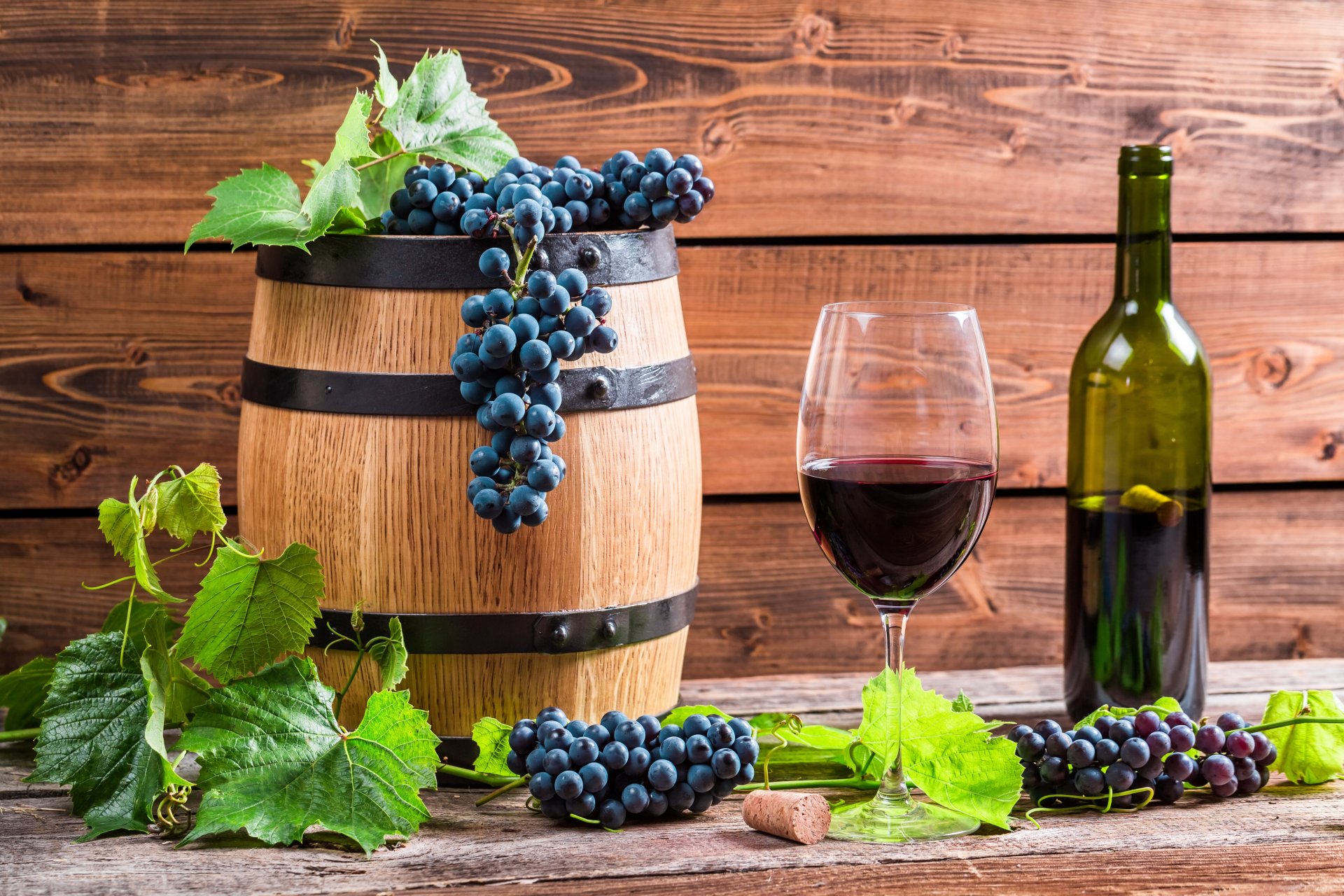 barrel a bottle glass wine red grapes vine leave