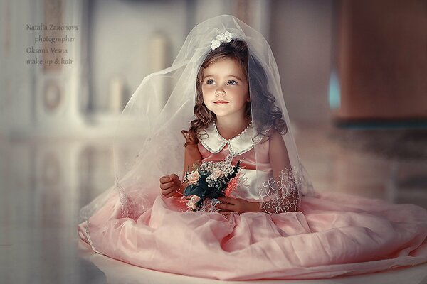 Una niña con un vestido de novia. Un niño con un ramo