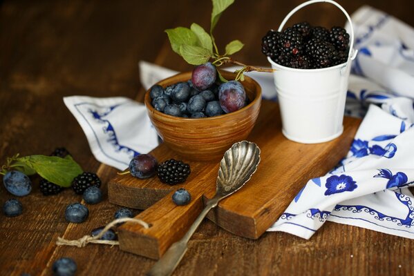 Pflaume mit Blaubeeren und Brombeeren auf Holzbrett