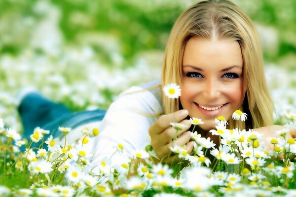 A beautiful girl lies among daisies