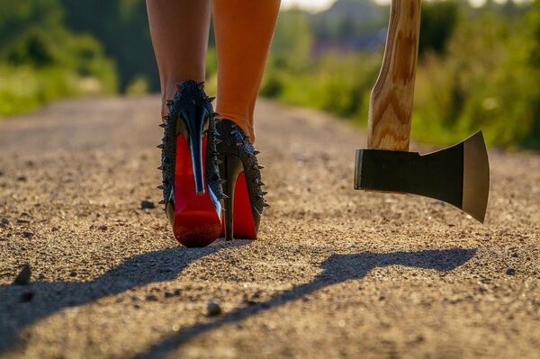 Femme fatale in shoes and with an axe