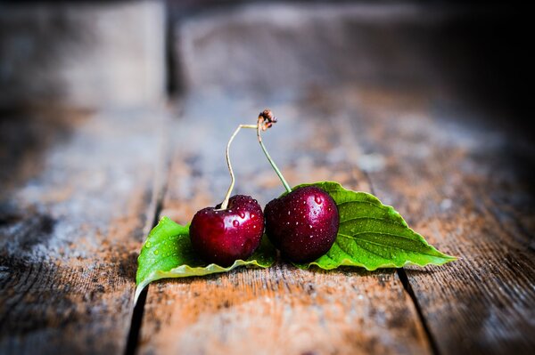 Fresh cherry on a wooden table with leaves