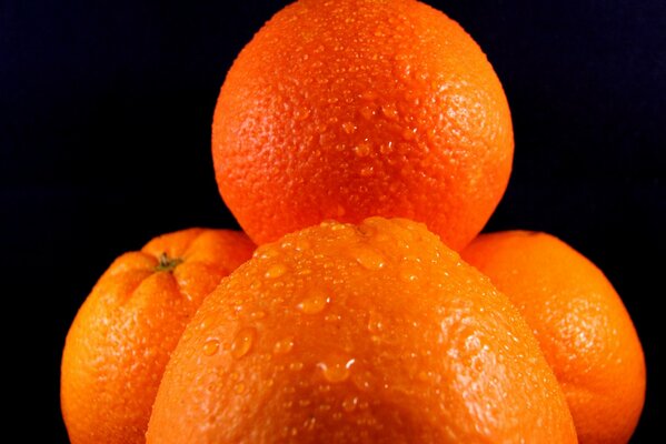 Water drops on oranges on a black background