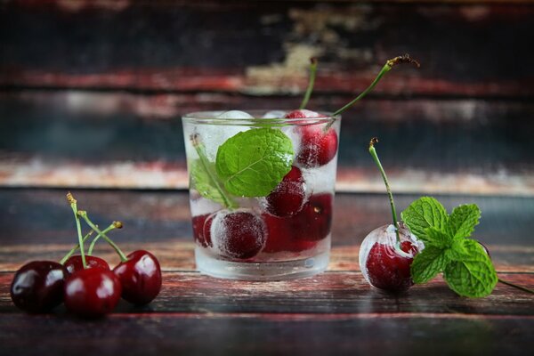 Cocktail with cherries, mint and ice