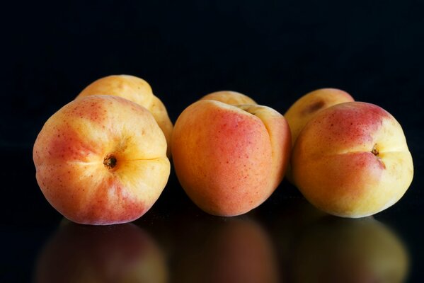 Abricots réfléchis sur fond noir