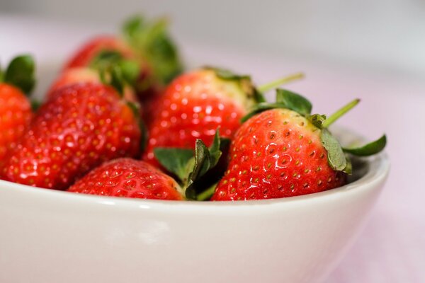 Fresas frescas, jugosas y maduras en una taza blanca