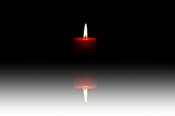 Reflection of a burning candle on a white background