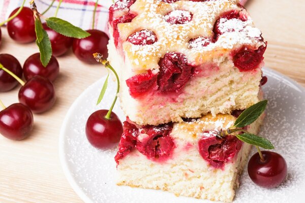 Ciasto czereśniowe w cukrze pudrze i świeżych jagodach