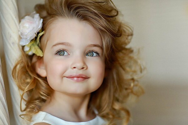 Una niña con una flor en el pelo. Hermoso bebé