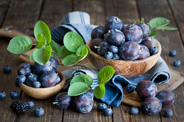 Heidelbeeren und Pflaumenbeeren in Holztellern