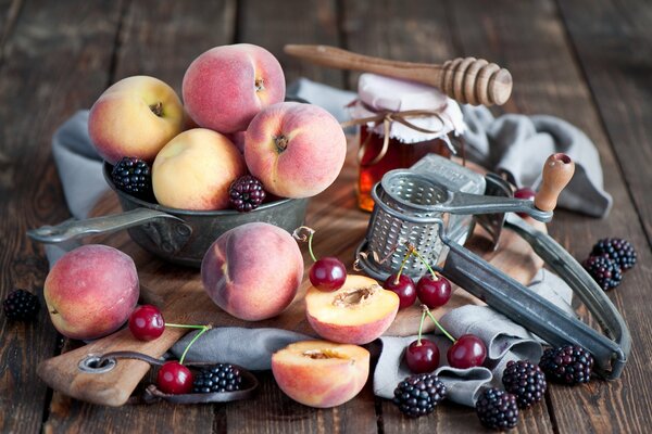 Pfirsiche in einer Schüssel mit Kirschen und Brombeeren