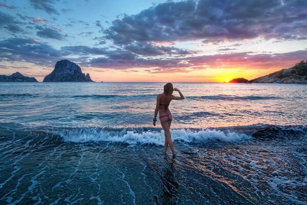 A girl on the background of the sunset surf