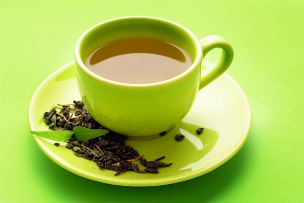 Té en una taza verde sobre un fondo verde