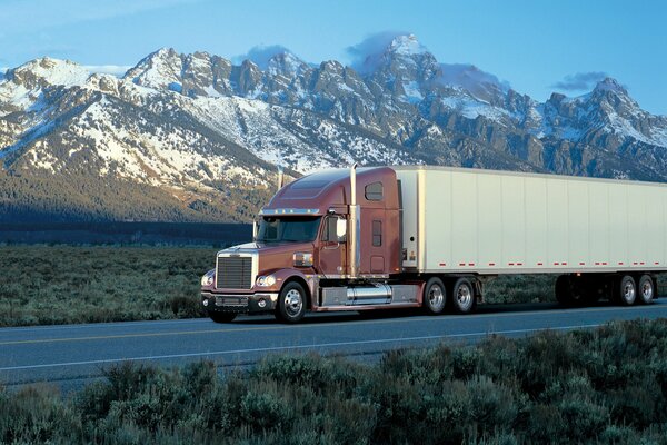 Camion sur la route sur fond de montagnes