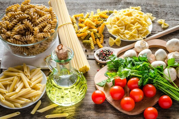 Table avec différents types de pâtes et tomates