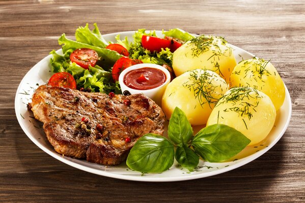 Dish with round potatoes, steak and herbs