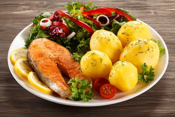 Filete de salmón con papas al horno y ensalada en un plato