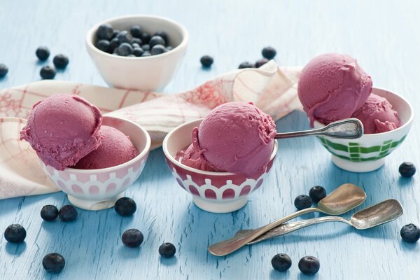 Tres postres con helado y un plato de arándanos