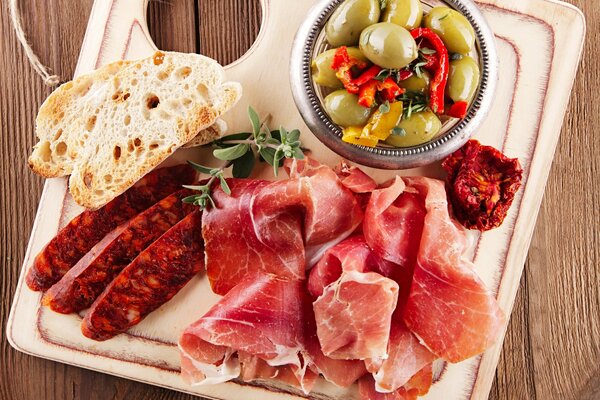 Prodotti a base di carne e verdure con pane su tavola di legno