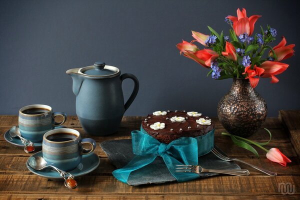 Bouquet of flowers on the table with cake and tea