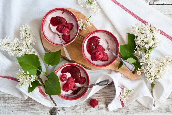 Joghurt mit frischen Beeren, Zweige aus weißem Flieder