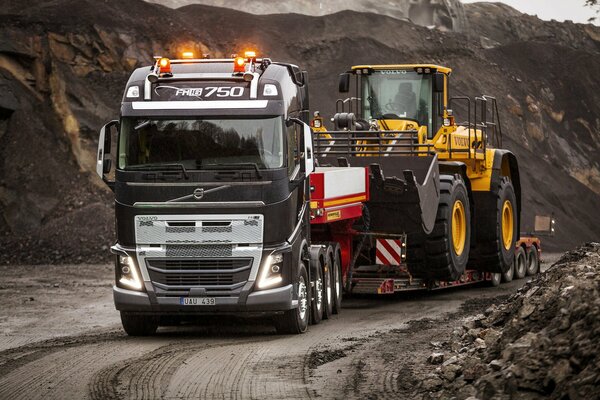 Camión Volvo transportando tractor