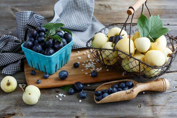 Heidelbeeren und Äpfel in der Komposition auf einem Holztablett